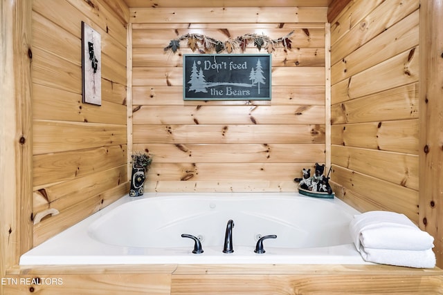 full bath featuring a garden tub and wood walls
