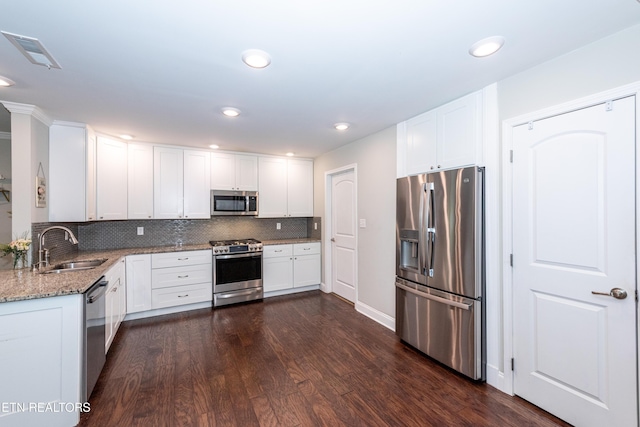 3132 Bakertown Station Way, Knoxville, TN 37931 - kitchen with stainless steel appliances, light stone countertops, dark wood-type flooring, decorative backsplash, and white cabinetry