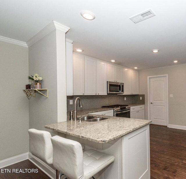 3132 Bakertown Station Way, Knoxville, TN 37931 - kitchen featuring appliances with stainless steel finishes, ornamental molding, backsplash, a peninsula, and white cabinetry