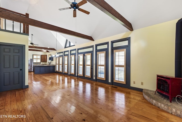 310 Savannah Shores Dr, Delano, TN 37325 - unfurnished living room featuring a ceiling fan, beamed ceiling, a wood stove, hardwood / wood-style flooring, and high vaulted ceiling