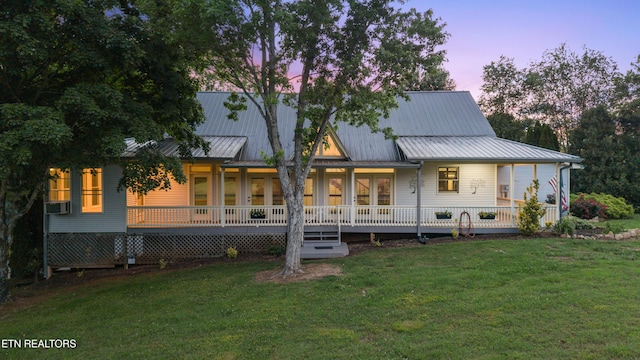 310 Savannah Shores Dr, Delano, TN 37325 - back of property at dusk featuring a lawn, covered porch, and metal roof