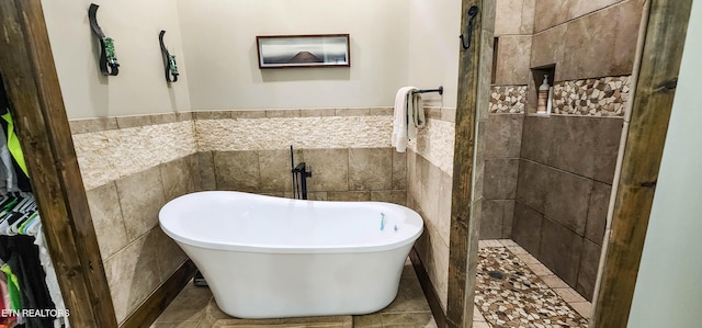 635 Norris Shores Dr, Sharps Chapel, TN 37866 - bathroom featuring tile walls, a soaking tub, tiled shower, and a wainscoted wall