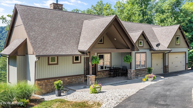 635 Norris Shores Dr, Sharps Chapel, TN 37866 - view of front facade with a chimney, roof with shingles, driveway, and stone siding