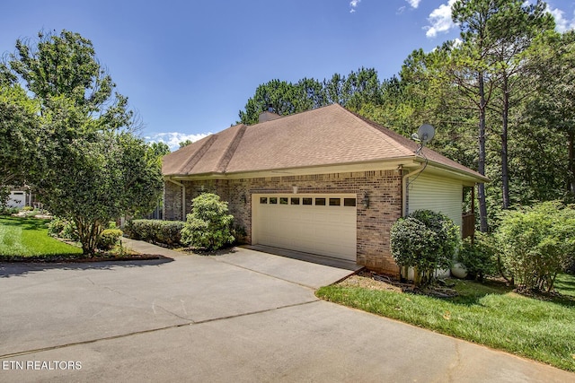307 Okmulgee Cir, Loudon, TN 37774 - view of front of home with brick siding, concrete driveway, a garage, a chimney, and a shingled roof