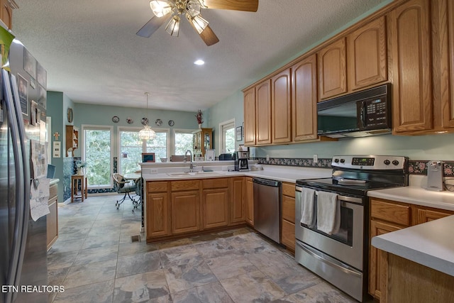 307 Okmulgee Cir, Loudon, TN 37774 - kitchen with stainless steel appliances, a sink, a ceiling fan, brown cabinets, and recessed lighting