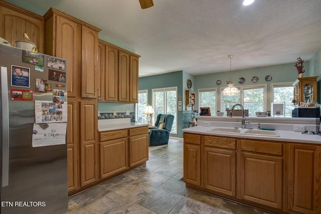 307 Okmulgee Cir, Loudon, TN 37774 - kitchen with freestanding refrigerator, a sink, light countertops, brown cabinetry, and a textured ceiling