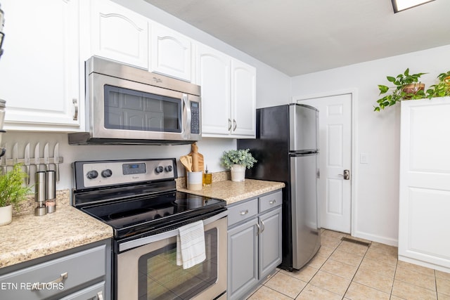409 Melrose St, Maryville, TN 37803 - kitchen with appliances with stainless steel finishes, gray cabinetry, light countertops, light tile patterned floors, and white cabinetry