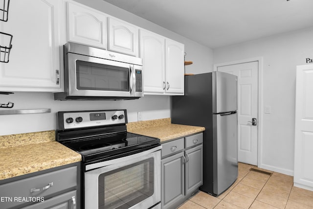 409 Melrose St, Maryville, TN 37803 - kitchen with stainless steel appliances, gray cabinets, light countertops, light tile patterned flooring, and white cabinetry