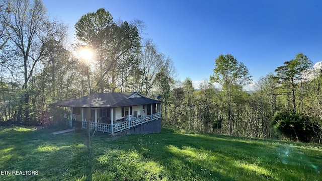 647 S Sudenny Ln, Lafollette, TN 37766 - rear view of house with covered porch, a yard, and a forest view