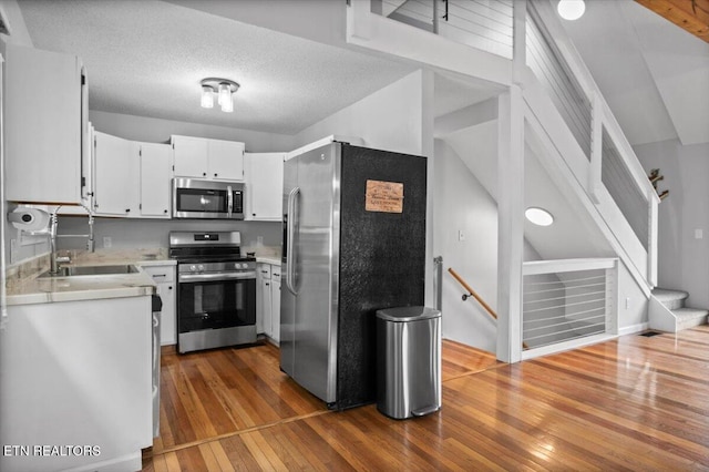 148 Mariner Point Rd, Lafollette, TN 37766 - kitchen with appliances with stainless steel finishes, a sink, light countertops, dark wood-style floors, and white cabinetry