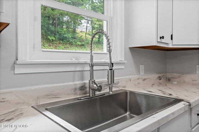 148 Mariner Point Rd, Lafollette, TN 37766 - kitchen view of a sink, white cabinets, and light stone counters