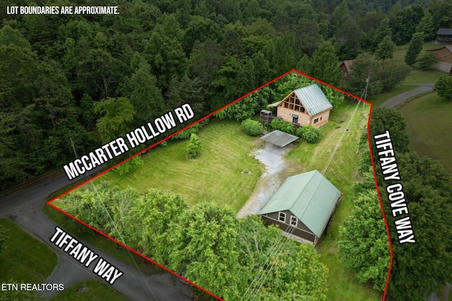 view from above of property with property boundaries highlighted and a heavily wooded area