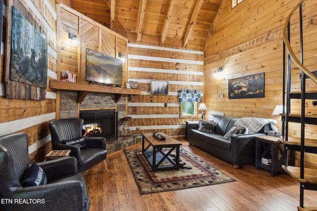 living area featuring wooden ceiling, wooden walls, wood-type flooring, and a fireplace