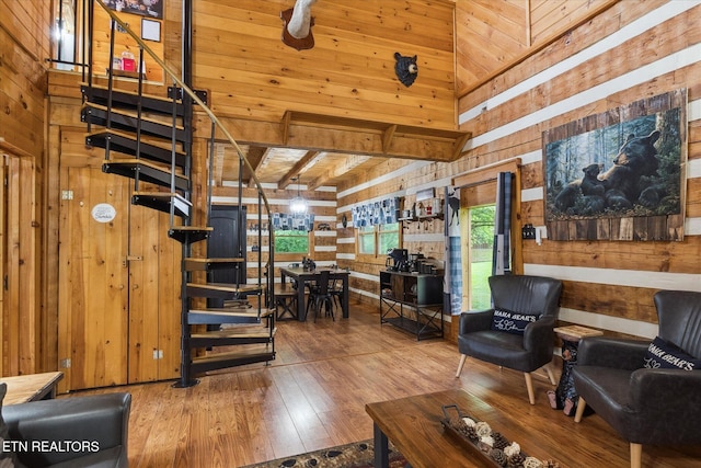 living area with wood walls and hardwood / wood-style flooring