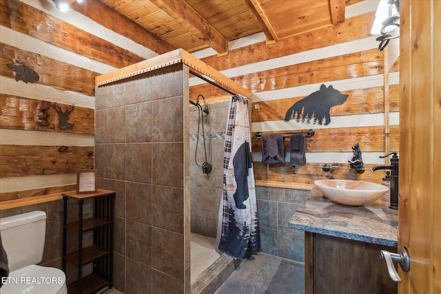 full bath featuring wooden ceiling, a tile shower, vanity, toilet, and beam ceiling