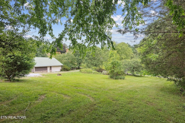 view of grassy yard featuring a garage