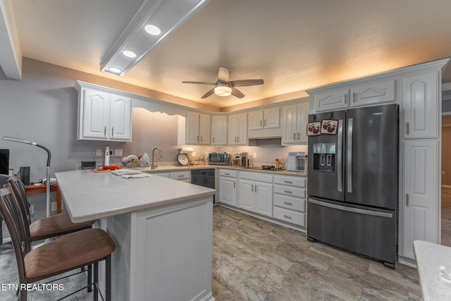 409 Turner Rd, Crossville, TN 38555 - kitchen with black appliances, a breakfast bar area, a peninsula, a ceiling fan, and light countertops