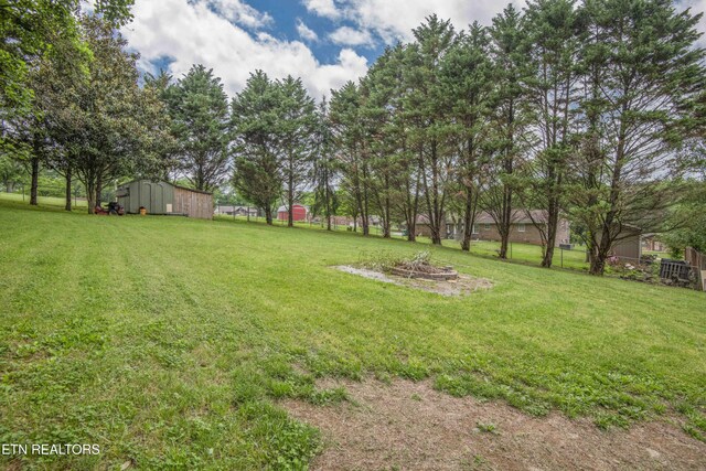 view of yard with an outdoor structure and an outdoor fire pit