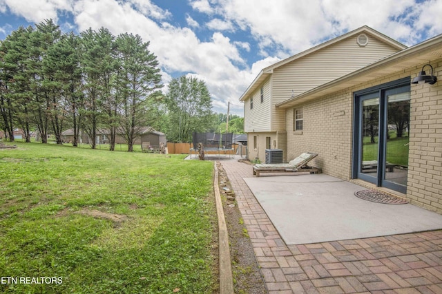 view of yard featuring a patio area, central AC unit, and a trampoline