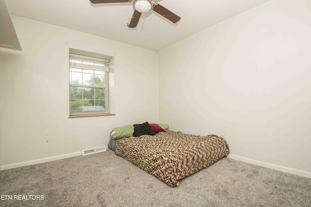 carpeted bedroom with crown molding, baseboards, and a ceiling fan