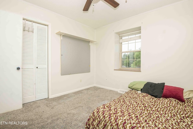 bedroom featuring carpet, ornamental molding, a closet, ceiling fan, and baseboards