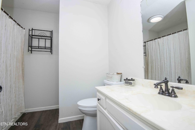 full bathroom featuring wood finished floors, toilet, vanity, and baseboards