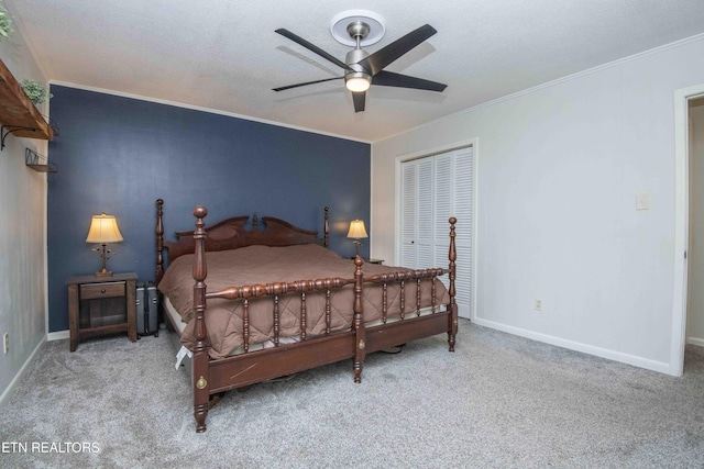 carpeted bedroom featuring crown molding, baseboards, a ceiling fan, and a closet
