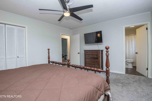 carpeted bedroom featuring crown molding, a closet, connected bathroom, a ceiling fan, and baseboards