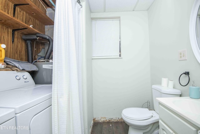bathroom featuring washer / clothes dryer, water heater, toilet, vanity, and wood finished floors