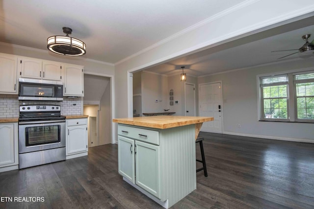 kitchen with appliances with stainless steel finishes, butcher block counters, dark wood-style flooring, backsplash, and a breakfast bar area