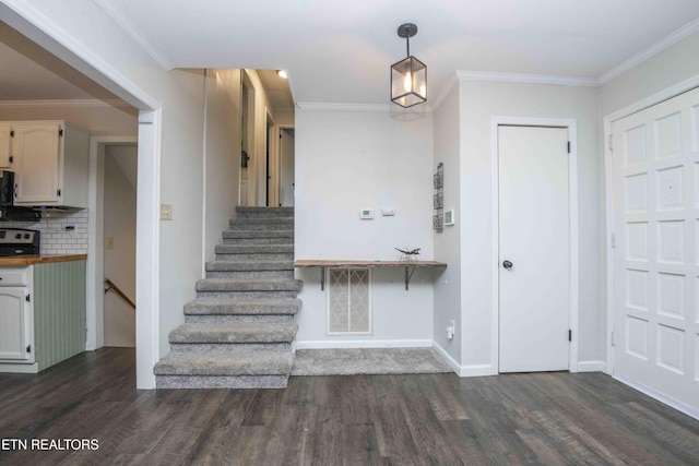 foyer featuring dark wood-style flooring, stairway, baseboards, and crown molding
