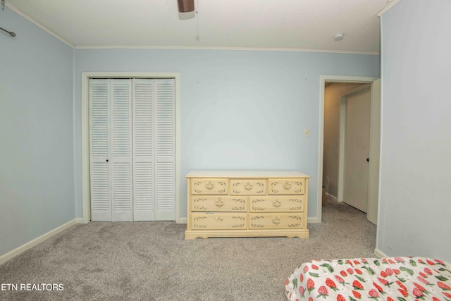carpeted bedroom with ornamental molding, a closet, a ceiling fan, and baseboards