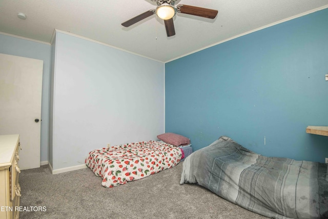 carpeted bedroom featuring ornamental molding, a ceiling fan, and baseboards