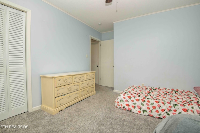 bedroom with ornamental molding, light colored carpet, a closet, and baseboards