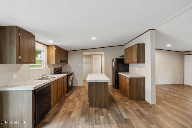 4001 Lilac Ave, Knoxville, TN 37914 - kitchen featuring black appliances, a sink, light countertops, light wood finished floors, and a kitchen island