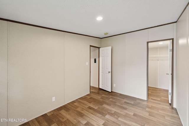 4001 Lilac Ave, Knoxville, TN 37914 - unfurnished bedroom featuring light wood-style floors, a walk in closet, crown molding, a closet, and recessed lighting