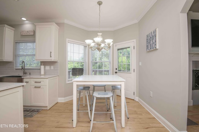 160 Brentwood Pl, Lenoir City, TN 37772 - dining space featuring crown molding, a chandelier, light wood-style flooring, healthy amount of natural light, and baseboards