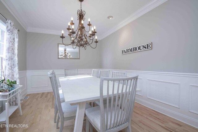 160 Brentwood Pl, Lenoir City, TN 37772 - dining area featuring a chandelier, light wood-type flooring, crown molding, a wainscoted wall, and a decorative wall