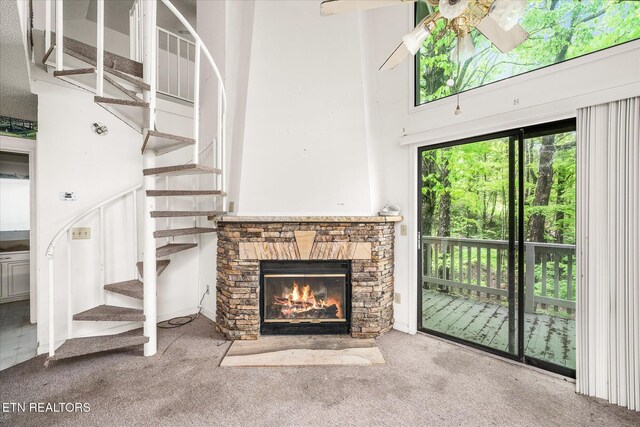 281 Moytoy Rd Unit 204, Crab Orchard, TN 37723 - unfurnished living room featuring stairway, a stone fireplace, carpet flooring, ceiling fan, and a high ceiling