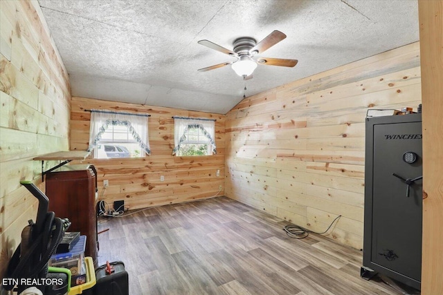 180 Stevenson Branch Rd, Middlesboro, KY 40965 - spare room featuring wood walls, a ceiling fan, wood finished floors, a textured ceiling, and vaulted ceiling