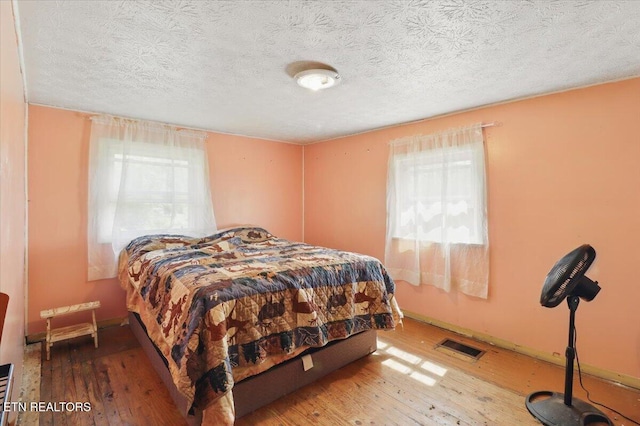 180 Stevenson Branch Rd, Middlesboro, KY 40965 - bedroom featuring multiple windows, wood-type flooring, and a textured ceiling