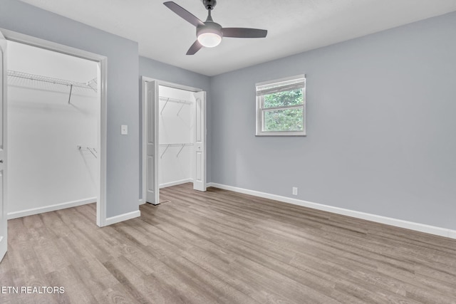 3694 Hickory Valley Rd, Maynardville, TN 37807 - unfurnished bedroom featuring wood finished floors, baseboards, a ceiling fan, and multiple closets