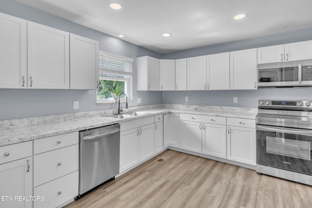 3694 Hickory Valley Rd, Maynardville, TN 37807 - kitchen with appliances with stainless steel finishes, a sink, white cabinetry, light wood-style flooring, and recessed lighting