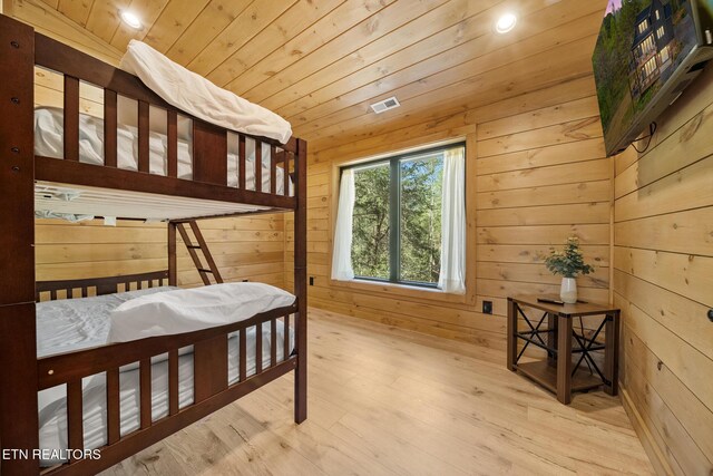 bedroom featuring wooden ceiling, wooden walls, wood finished floors, and recessed lighting