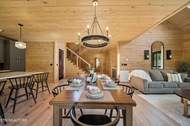 dining space with stairs, wooden ceiling, wooden walls, light wood-style flooring, and lofted ceiling