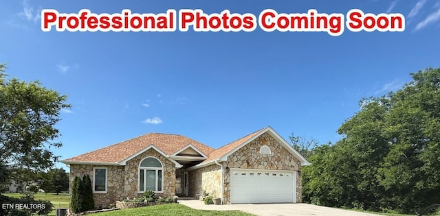 407 Kahite Trl, Vonore, TN 37885 - view of front of house featuring stone siding, a garage, a front lawn, and concrete driveway