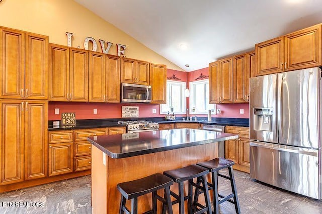 241 Oswego Rd, Jellico, TN 37762 - kitchen featuring appliances with stainless steel finishes, lofted ceiling, brown cabinets, a sink, and a breakfast bar