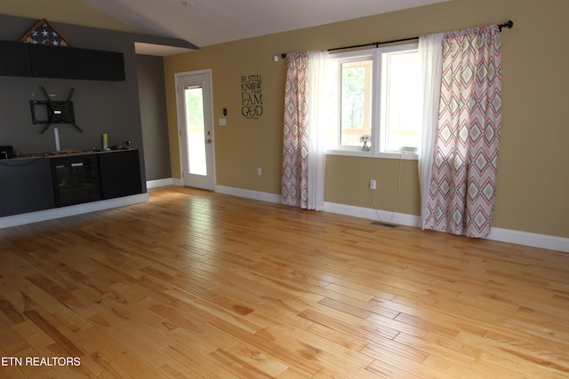 241 Oswego Rd, Jellico, TN 37762 - unfurnished living room with light wood-style flooring, baseboards, bar area, and vaulted ceiling