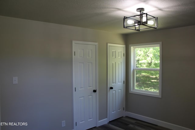 515 Silver Lake Dr, Jamestown, TN 38556 - unfurnished room featuring a chandelier, dark wood-style floors, baseboards, and a textured ceiling