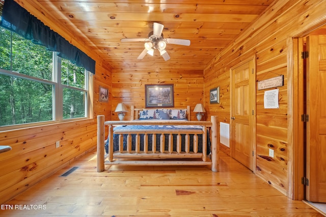 bedroom featuring light wood-type flooring, wood walls, wooden ceiling, and lofted ceiling